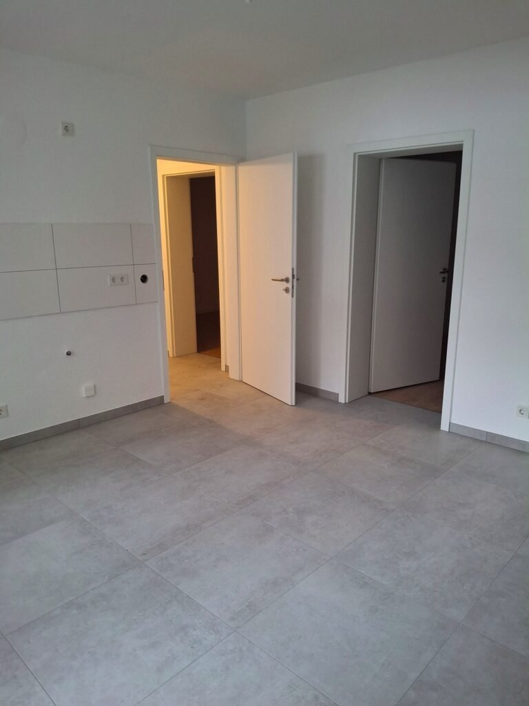 Verlegung von Bodenfliesen in Betonoptik bei Komplettsanierung einer Wohnung in Mannheim-Rheinau - Ansicht Eingang Küche