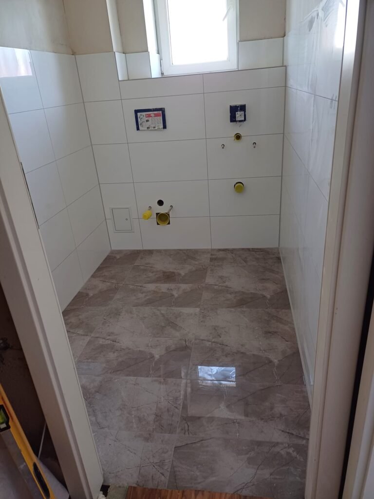 Sanierung Gäste-WC in Mannheim - Bodenfliesen in Hochglanz, weiße Wandfliesen - Endergebnis vor der Sanitärmontage