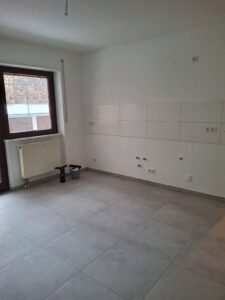 Verlegung von Bodenfliesen in Betonoptik bei Komplettsanierung einer Wohnung in Mannheim-Rheinau - Ansicht Fliesenspiegel und fertiger Boden Küche