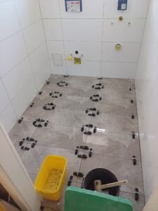 Sanierung Gäste-WC in Mannheim - Bodenfliesen in Hochglanz, weiße Wandfliesen - hier vor dem Verfugen