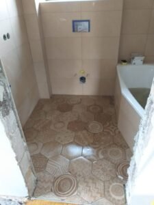 Renovierung eines Bades in Mannheim - Montage einer Badewanne, Verlegung von sechseckigen Bodenfliesen und hellbraunen Wandfliesen - Ansicht Boden
