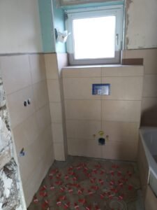 Renovierung eines Bades in Mannheim - Montage einer Badewanne, Verlegung von sechseckigen Bodenfliesen und hellbraunen Wandfliesen - Zustand nach der Verlegung von Bodenfliesen