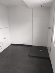 Verlegung von dunkelgrauen Großformatfliesen in einem Bad in Ludwigshafen - Duschbereich