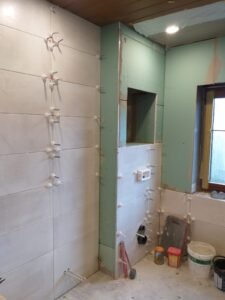 Umfassende Badrenovierung in Ludwigshafen - raumhohe Wandfliesen in Hellbraun und braune Bodenfliesen - Zwischenstand bei der Verlegung