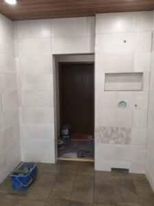 Umfassende Badrenovierung in Ludwigshafen - raumhohe Wandfliesen in Hellbraun und braune Bodenfliesen inklusive bodengleiche Dusche