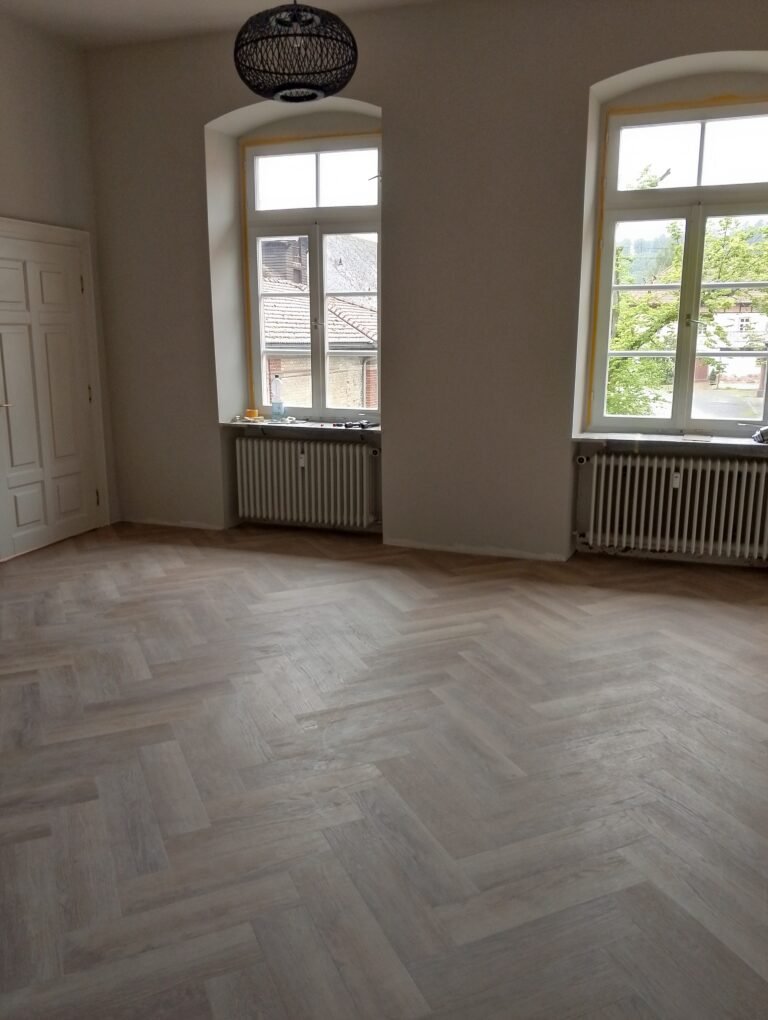 Alternative Text (Alt-Text): Vinylboden im Fischgrät-Muster fachgerecht verlegt auf Altfliesen – Ihr Bodenleger Mannheim